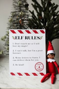 an elf is next to a sign that says elf rules