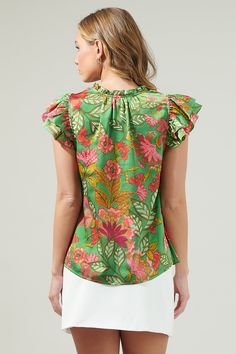 The Susy Paradise Bellissima Ruffle Sleeve Top will make you want another vacation with it’s tropical green and pink satin print. It has a highlighting silhouette followed by a split neckline and ruffle cap sleeves. The bodice maintains a classic fit that can easily be styled tucked into a pair of high waisted shorts and loafers for a classic look.- Cap sleeves- Split - Ruffle layers - Relaxed fit- Color: Green MultSize + Fit - Model is 5'8" and wearing size XS- Measurements taken from size S - Green Silk Blouse With Floral Print, Green Printed Tropical Tops, Green Tropical Printed Tops, Green Floral Silk Blouse, Summer Blouse With Vibrant Green Print, Green Vibrant Print Summer Blouse, Summer Green Blouse With Vibrant Print, Green Floral Print Blouse For Brunch, Green Vibrant Print Tops For Vacation