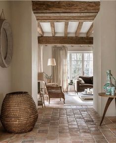 a living room filled with lots of furniture next to a wall covered in wood beams