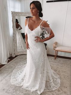 a woman in a white wedding dress posing for the camera with her hand on her hip