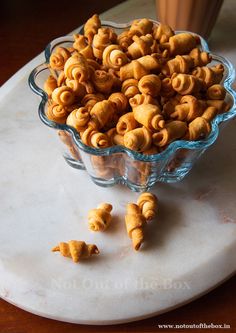 a glass bowl filled with cereal on top of a marble counter