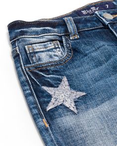 Mid-rise, medium dark-wash girls straight jeans- Silver and white embroidered stars throughout front and back design- Classic back pocket with matching motif- Embossed white leather Miss Me brand patch- Frayed bottom hems- Fading with whiskering details- 5-pocket design Measurements: USA WAIST HIP FRONT RISE X BACK RISE 7 23 3/4 28 3/4 7 1/4 X 11 3/4 8 24 1/2 29 1/2 7 1/2 X 12 10 25 1/2 30 1/2 7 3/4 X 12 1/4 12 26 1/2 31 1/2 8 X 12 1/2 14 27 1/2 32 1/2 8 1/4 X 12 3/4 16 28 1/2 33 1/2 8 1/2 X 13 Embroidered Stars, Stylish Girl, Miss Me, Pocket Design, Jeans Shop, Straight Jeans, White Leather, All Star, Mid Rise