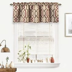 a window with a curtain and some vases on the shelf in front of it