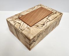 a wooden box sitting on top of a white table