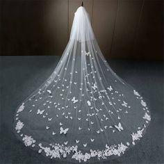 a wedding veil with white butterflies on the bottom and one layer of tulle is shown