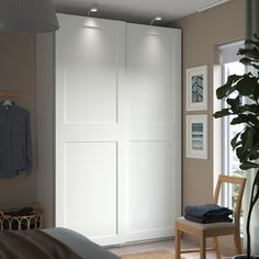 a bedroom with a bed, chair and white closet doors