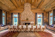 a living room with couches, chairs and a table in front of a fireplace