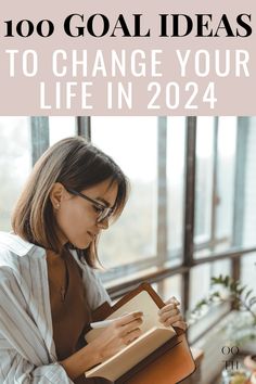 a woman sitting in front of a window reading a book with the title, 100 goal ideas to change your life in 2021