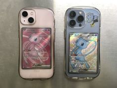 two cell phones sitting next to each other on top of a metal surface with stickers