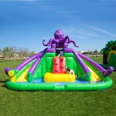 an inflatable bouncer with a dog on it and some water toys nearby