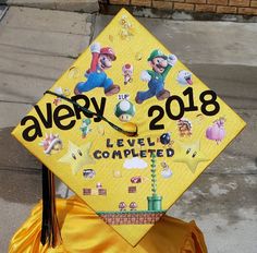 a yellow graduation cap with images of mario and luigi on it that says avery 2013