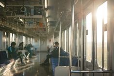 people are sitting on the subway train with their backs to each other as they look out the windows