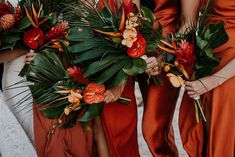 the bridesmaids are holding their bouquets with orange flowers and tropical greenery