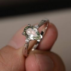 This is a gorgeous handmade creation. Its beauty is its simplicity & Elegance. The 6*9 mm pear shape faceted natural green amethyst is crafted in solid sterling silver and with rhodium plated. All item is sent in a beautiful gift box If you have any idea of design your ring,pls contact me directly. You can realize more lovely stuff clicking the link https://www.etsy.com/shop/knightjewelry?refshopsection_shophome_leftnav Please leave the correct address and you phone number for delivering suc Teardrop Amethyst Ring For Anniversary, Garnet Wedding Rings, Swiss Blue Topaz Ring, Red Garnet Ring, Green Gemstone Ring, June Birthstone Ring, Blue Gemstone Rings, Green Amethyst Ring, Alexandrite Engagement Ring