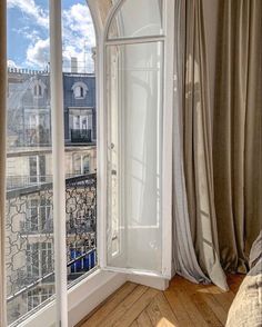 an open window in a bedroom overlooking the city