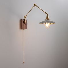 a wall mounted light on the side of a white wall next to a lamp fixture