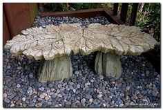 a large leaf shaped bench sitting on top of a pile of rocks