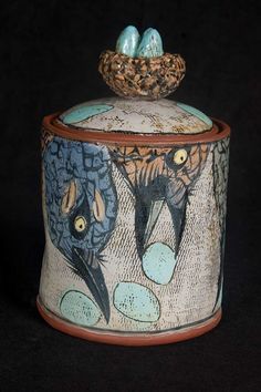 a ceramic container with two birds on it