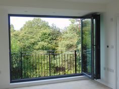 an empty room with a balcony overlooking the trees