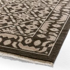 a brown and white area rug with an intricate design on the bottom half of it