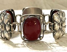 "A rare bracelet by Jane Carson Barron and Frances Barnum Smith, Arts and Crafts, Cleveland, OH. The two women had a studio in Cleveland for a short period together from 1902-1905. The bracelet features oval red stones that I believe to be petrified wood. The bracelet measures 7\" x 1\". Good condition, some tarnish and patina. Circa 1902-1905 33.95g" Antique Adjustable Bracelets For Formal Occasion, Antique Sterling Silver Adjustable Bracelet For Formal Occasions, Victorian Polished Bracelets For Formal Occasions, Adjustable Antique Sterling Silver Bracelet For Formal Occasions, Victorian Polished Finish Bracelet Gift, Vintage Sterling Silver Cabochon Bracelets, Vintage Sterling Silver Bracelets With Cabochon, Vintage Cabochon Bracelet Gift, Vintage Cabochon Bracelets As Gift