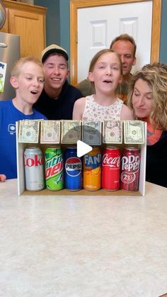 a group of people standing in front of a counter filled with soda cans and money