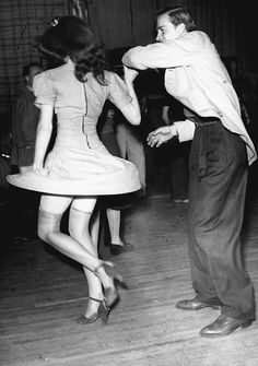 an old photo of two people dancing on the dance floor