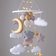 a crib mobile with stars, clouds, and an elephant hanging from the ceiling