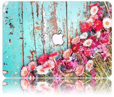 an apple logo on the side of a wooden wall with flowers