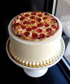 a large pepperoni pizza on top of a white cake