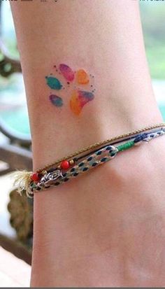 a woman's foot with a colorful tattoo on it