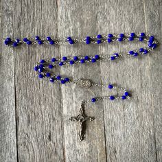 The Beads: Cobalt blue pressed glass beads from the Czech Republic. The Crucifix & Center: The same friend I got the beads from went to the Czech Republic, roughly 20 years ago. She was visiting a local glass factory there. One of the owners helped her put together her bead order. Before she left he pulled out a dusty box containing these beauties. This crucifix features glass rhinestones. Why I Make Rosaries: As far back as I can remember my grandmother prayed the rosary at least 2 times a Handmade Blue Rosary For Jewelry Making, Blue Beaded Rosary As A Gift, Blue Czech Glass Beaded Chain, Blue Glass Beads For Gifts, Blue Glass Beads For Gift, Blue Glass Faceted Beads, Blue Faceted Glass Beads, Blue Glass Spiritual Beads, Spiritual Blue Glass Beads