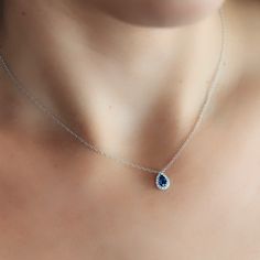 Indulge in tranquil beauty with this Pear Shaped Blue Sapphire and Diamond Halo Necklace. Perfect for gifting to a loved one (or yourself - no judgment here!) wear with our matching bracelet, ring, and earrings. Natural Blue Sapphire: 0.40cts Natural Diamonds: 0.05ctw 18K White Gold Length: 16 Inches Blue Sapphire Drop Jewelry, Fine Jewelry Oval Hand Set, Oval Hand Set Jewelry Gift, Blue Gemstone Drop Jewelry, Blue Drop Gemstone Jewelry, Hand Set Oval Jewelry Gift, White Gold Hand Set Jewelry Gift, White Gold Jewelry With Hand Set Details For Gift, Diamond Drop Jewelry With Polished Finish