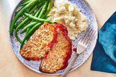 meatloaf, mashed potatoes and green beans on a plate with a fork