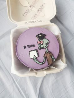 a decorated cookie in a box on a bed