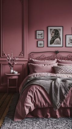 a bedroom with pink walls and pictures on the wall above the bed, along with an area rug