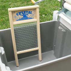 a wooden sign sitting in the middle of a trash can with an orange handle on it