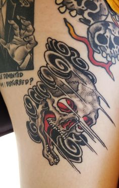 a close up of a person's thigh with tattoos on it and skulls in the background