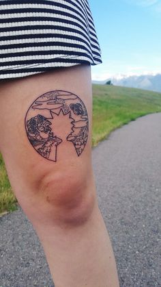 a person with a small tattoo on their leg that shows the world in a circle