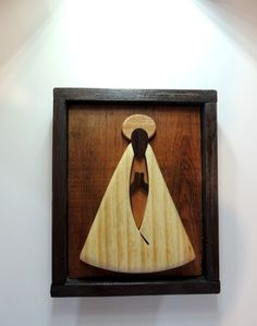 a wooden cut out of a man's face in a frame on the wall