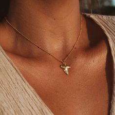 Channel the adventurous spirit of the ocean with this captivating shark tooth necklace. The gold plated shark tooth pendant, crafted with sterling silver, adds a touch of elegance and intrigue to your beach-inspired style. Suspended on a 14k gold filled chain, this necklace embodies a perfect blend of durability and beauty. Whether you're a beach lover, a shark enthusiast, or simply seeking a unique accessory, this necklace is a stunning addition to your collection. Embrace the power and allure Shark Tooth Necklace Gold, Lavender Necklace, Shark Tooth Pendant, Tooth Pendant, Pebble Pendant, Shark Tooth Necklace, Tooth Necklace, Shark Tooth, Elegant Pendant