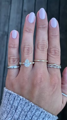 a woman's hand with two different rings on it and one has a diamond in the middle