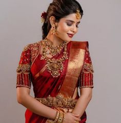 a woman wearing a red and gold sari