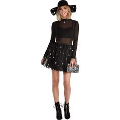 a woman wearing a black dress and hat with stars on the skirt is standing in front of a white background