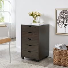 a wooden cabinet with three drawers next to a basket and chair in front of a window