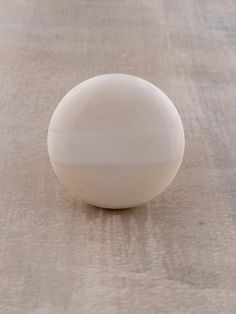 a white object sitting on top of a wooden table next to a brown cloth covered floor