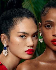 two models with red lipstick and green earrings