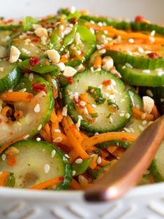 a salad with cucumbers, carrots and sesame seeds