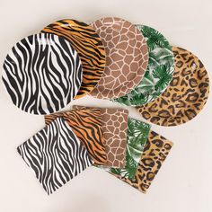 five animal print paper plates on a white surface