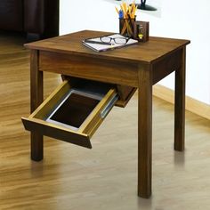 a wooden table with an open drawer underneath it on the floor next to a couch